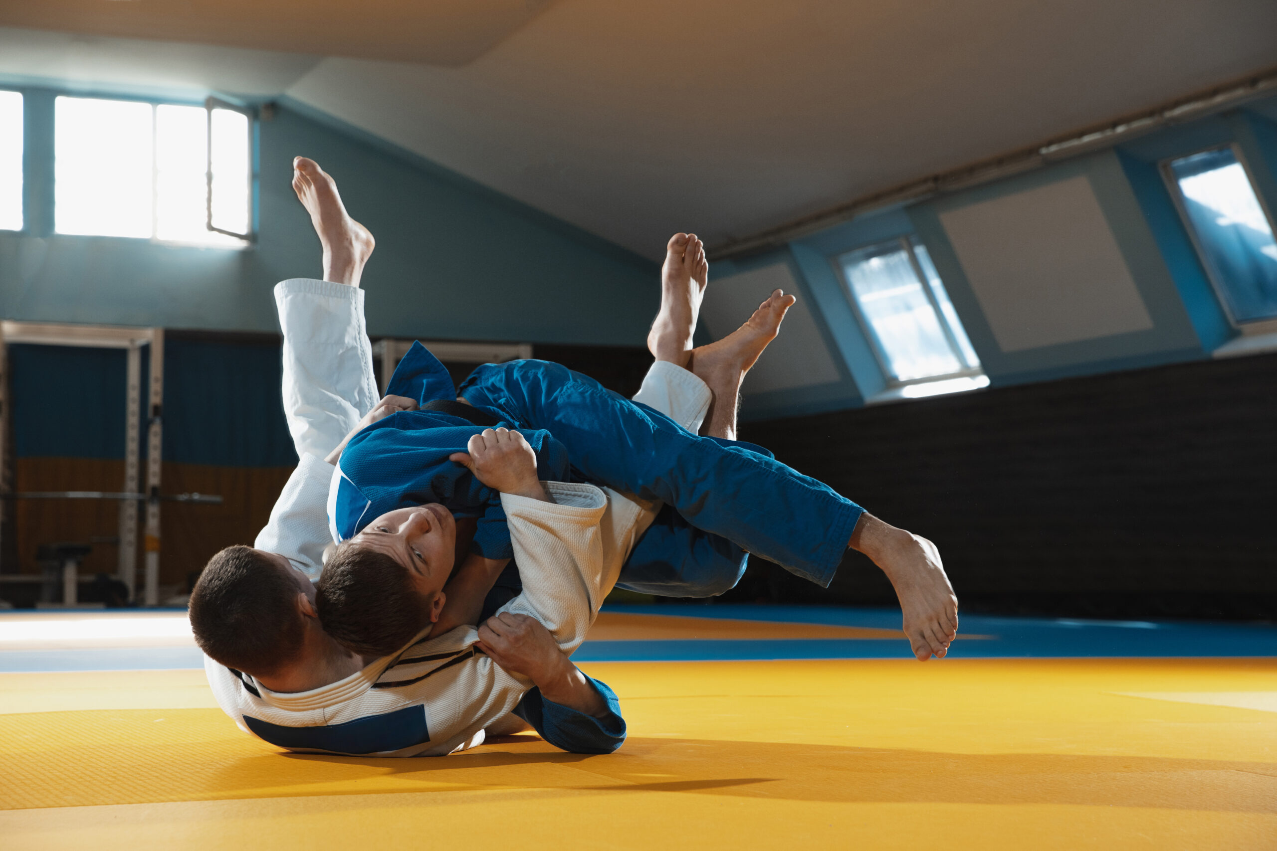 two young judo fighters in kimono training martial arts in the gym with expression, in action and motion